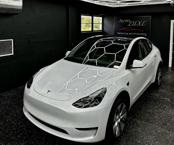 A front three-quarter view of a high-end sports car inside a modern automotive workshop