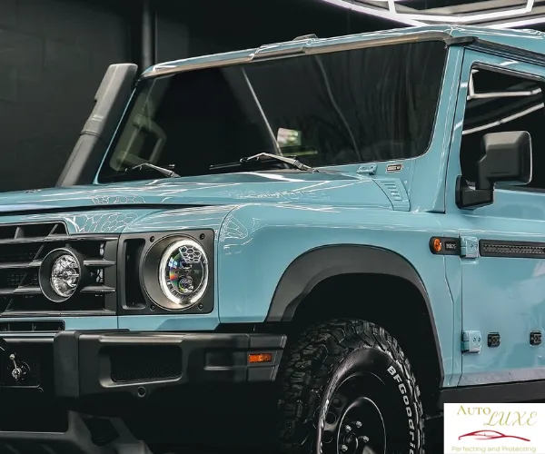 A close-up front view of a light blue rugged off-road SUV featuring a high-gloss finish